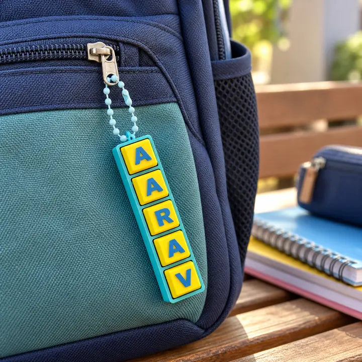 A Fidget Clicker clipped to the zip pull of a navy backpack.
