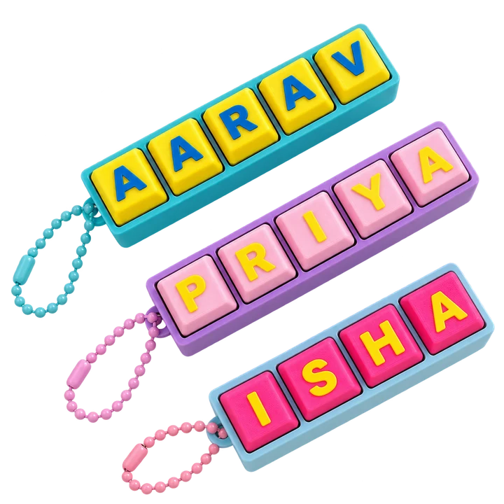Three Fidget Clicker keychains spelling AARAV, PRIYA and ISHA, each on a ball chain.